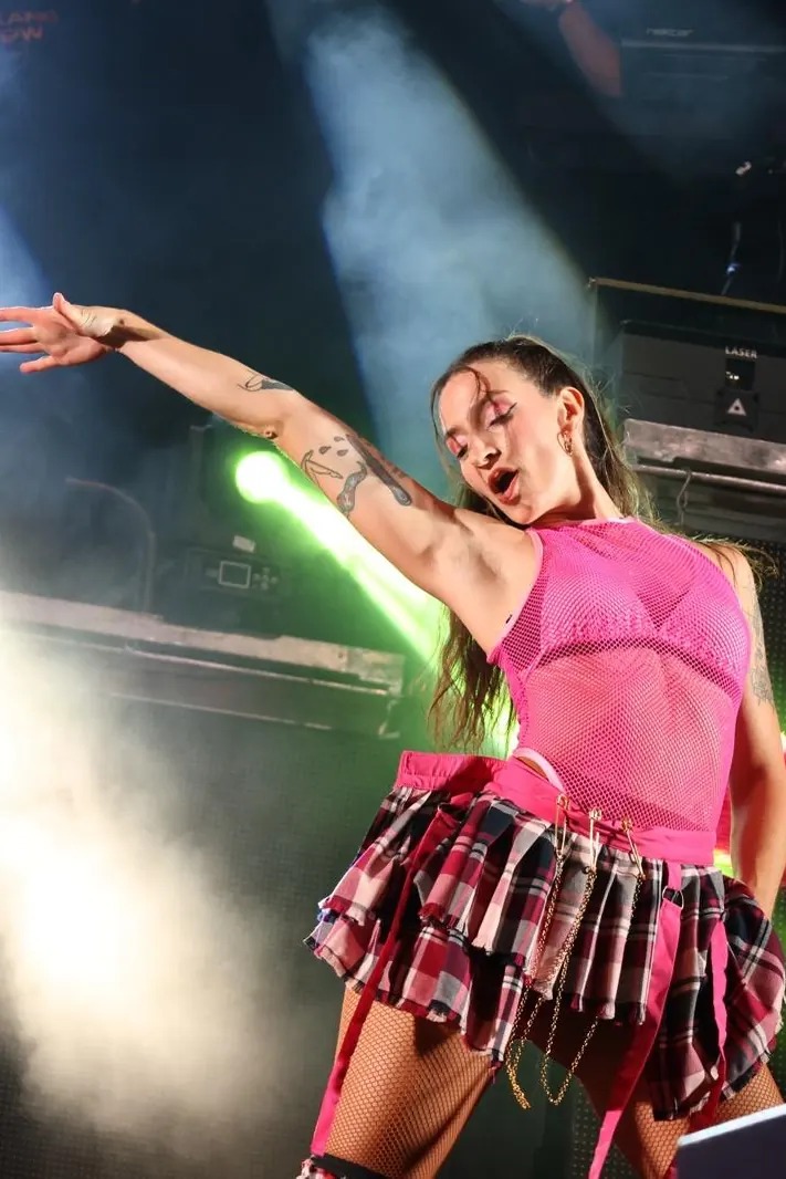 Julia Vicente bailando en el escenario con vestuario rosa y el brazo extendido